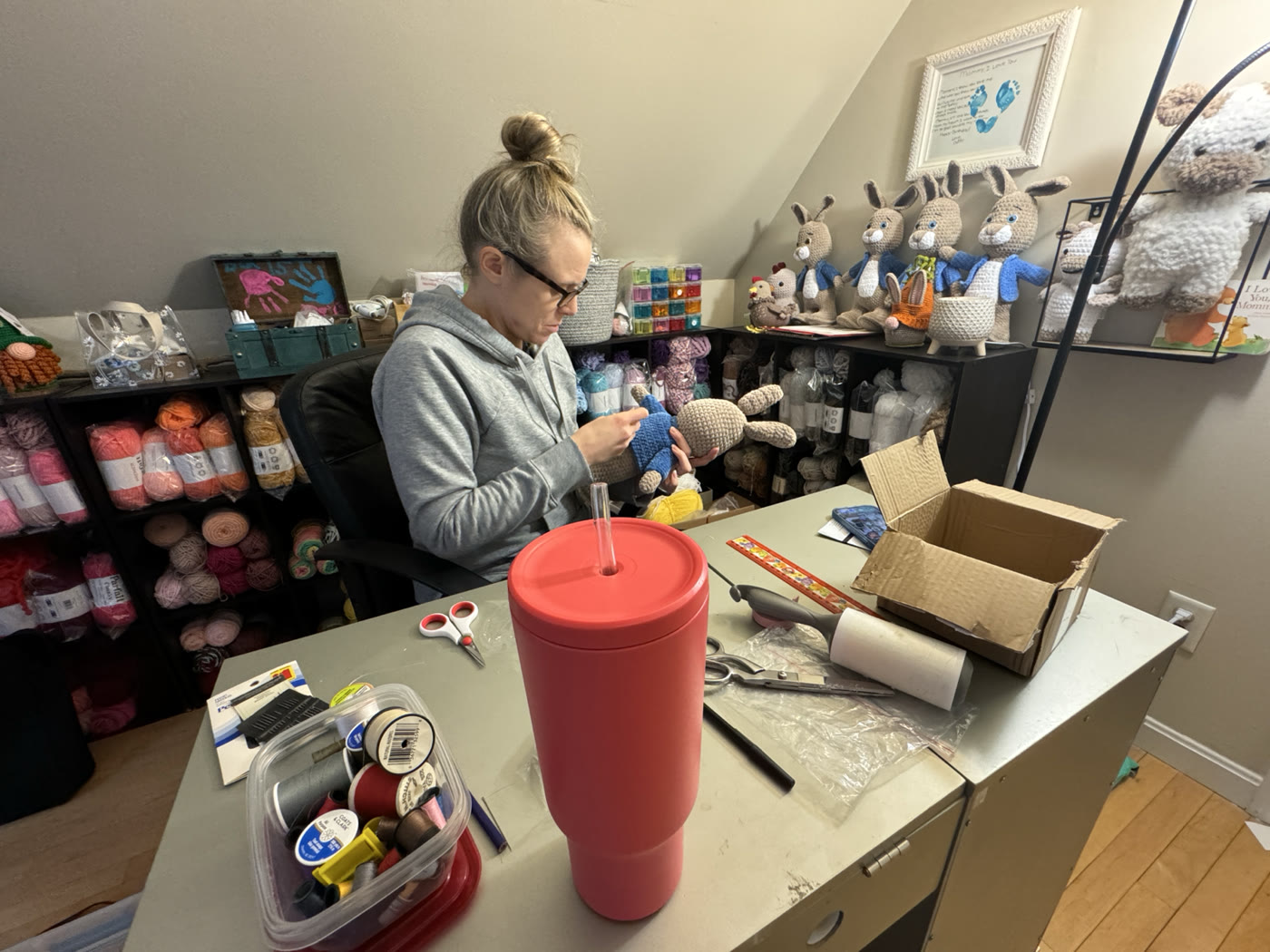Krissy crocheting an amigurumi rabbit in her yarn-filled workspace